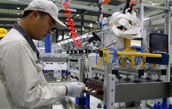 A worker operates a machine that makes key parts of high-speed trains at Zhuzhou Electric Locomotive Co. (Liu Weifeng / China Daily)