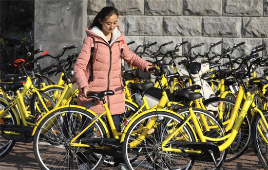 A student uses an ofo bike on the campus of the University of International Business and Economics in Beijing. (ZHU XINGXIN / CHINA DAILY)
