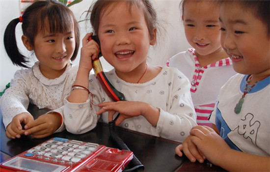 Children use a landline phone in a kindergarten in Chaohu, Anhui province. (MA FENGCHENG / FOR CHINA DAILY)