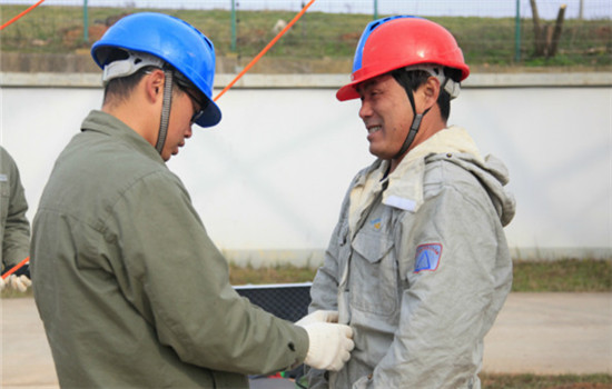 Yan Yu, son of Yan Xudong, assists him in wearing the uniform before starting work on UHV electricity cables at a UHV AC Test Base of SGCC in Wuhan, capital of Central China's Hubei province, on November 30, 2016. (Photo by Zhu Lingqing/chinadaily.com.cn)