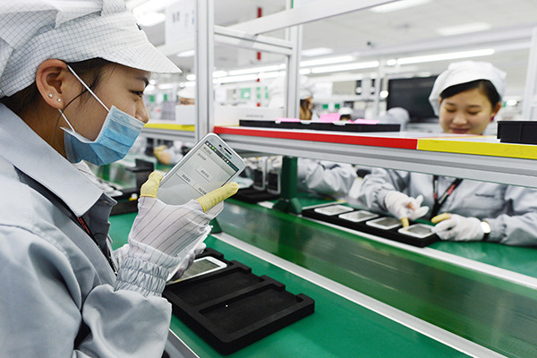 Workers test mobile phones at a plant in Wuhan, Hubei province. (Photo/China Daily)