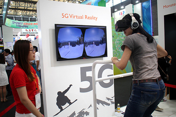 A consumer experiences a virtual reality game device that applies 5G technology at a high-tech fair held in Shanghai in May last year. (Photo/China Daily)