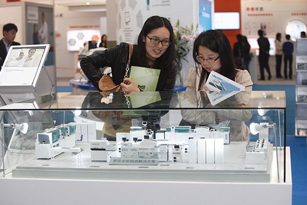 Visitors look at 3D-printed products at the Roche Group booth at a technology fair in Shanghai. (Photo/China Daily)