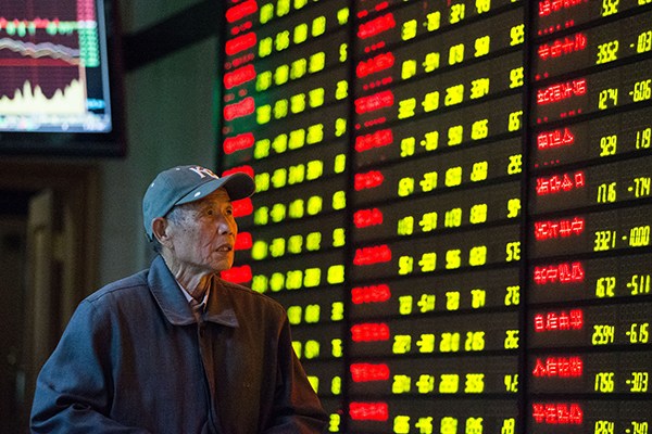 A pensioner, tension writ large on his face, checks stock prices at a brokerage in Nanjing, Jiangsu province, on Dec 12, when Chinese stocks fell the most in six months. (Photo/China Daily)