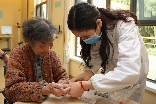 A caretaker conducts a health check for a senior citizen at Vanke's Dignified Life Project in Liangzhu, Zhejiang province. (Photo provided to China Daily)
