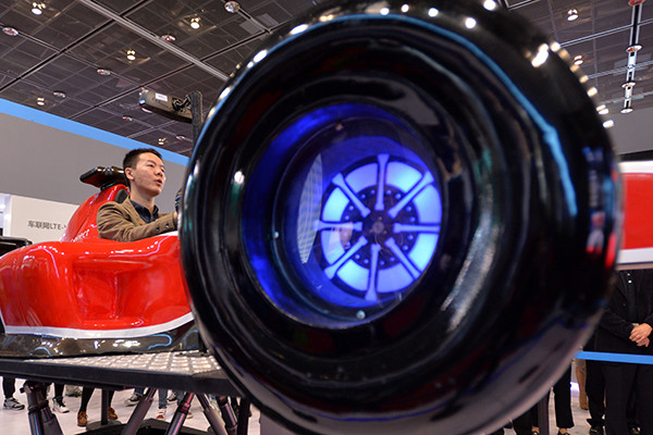 A visitor tries applications of China Mobile Communications Corp at the telecom carrier's booth at the World Internet of Things Expo in Wuxi, Jiangsu province. (Photo/China Daily)
