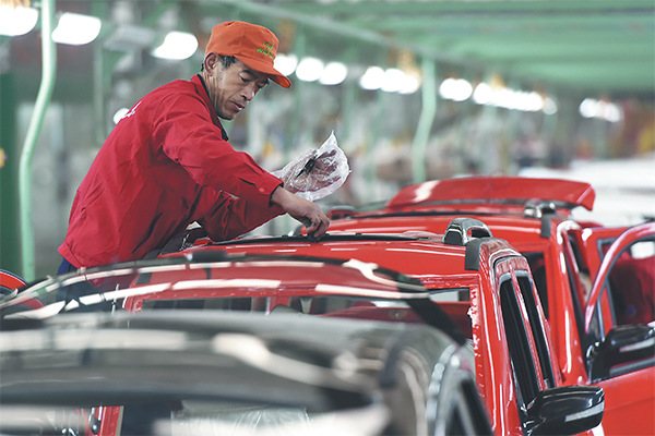 A worker works on electric cars at a plant in Zouping county, Shandong province. The fast-growing new energy vehicle sector now faces the risk of overcapacity. (Photo/Xinhua)