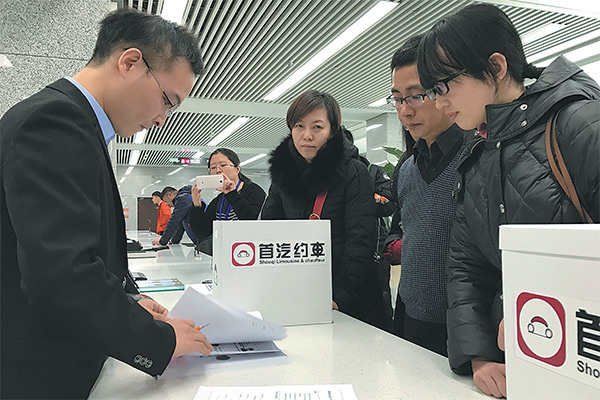 Representatives from car-hailing service provider Shouqi Limousine & Chauffeur submit materials to apply for licenses after the new rules were issued in Beijing. (Photo provided to China Daily)