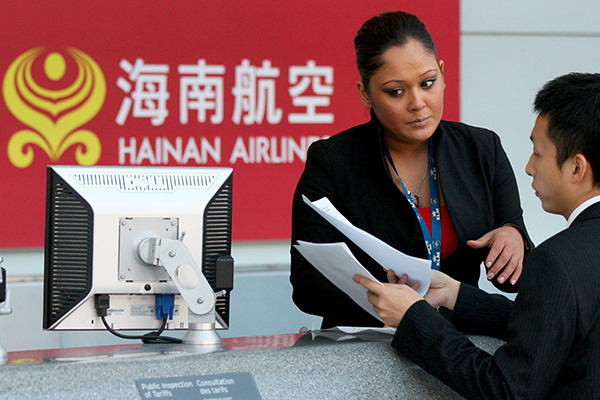 Two ground staff of Hainan Airlines prepare lists of passengers at the Pearson International Airport in Toronto, Canada. (Photo/Xinhua)