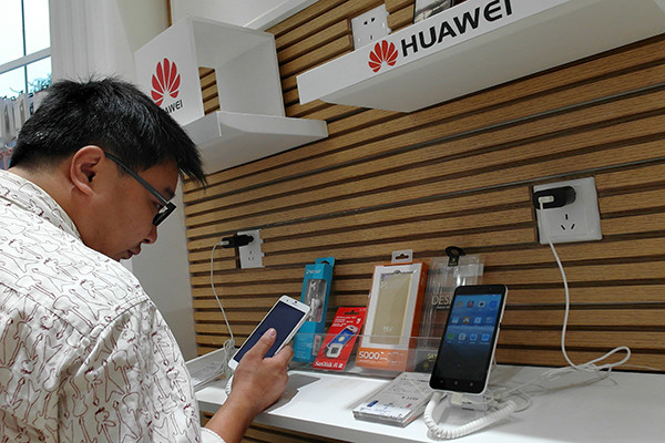 A consumer chooses from Huawei smartphones in Yichang, Hubei province. The Shenzhen-based Huawei Technologies Co Ltd is the world's third biggest handset maker. (Photo/China Daily)