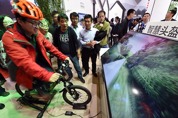 A visitor enjoys virtual bike racing at the World IoT Expo held in Jiangsu province in October. (Photo/China Daily)