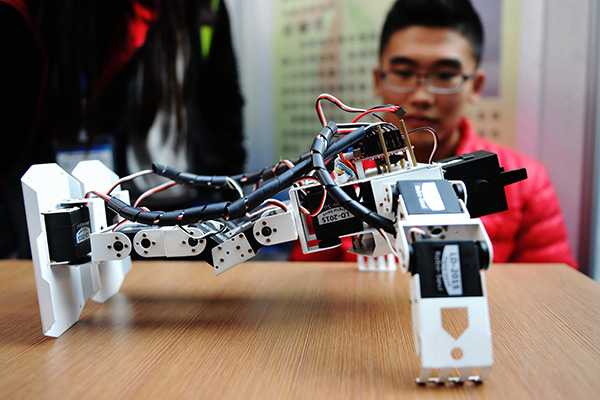 A voice-controlled robot designed by college students does push-ups at a show in Shandong province. (Photo/China Daily)