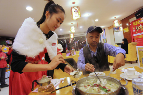 A waitress serves fish at a restaurant in Suzhou, Jiangsu province. (Photo provided to China Daily)