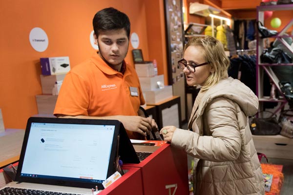 A shop assistant (left) helps a buyer place an online order for Chinese goods in Moscow, Russia. (Photo/Xinhua)
