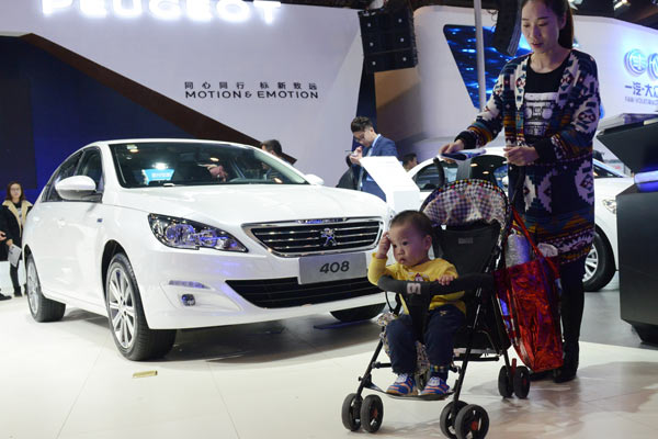 A young mother takes her child to an auto show in Zhengzhou, Henan province, on Nov 4, 2016. (Photo by Zhang Tao/For China Daily)