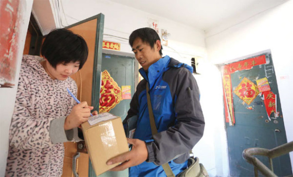 A 26-year-old woman receives goods she bought online in Dalian, Liaoning province. （Photo provided to China Daily）