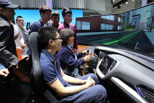 Visitors test a driving simulator during last year's Beijing auto show. With steady economic growth, experts say there is likely to be a sustained demand for automobiles in the years to come. (Photo by Wang Zhuangfei/China Daily)