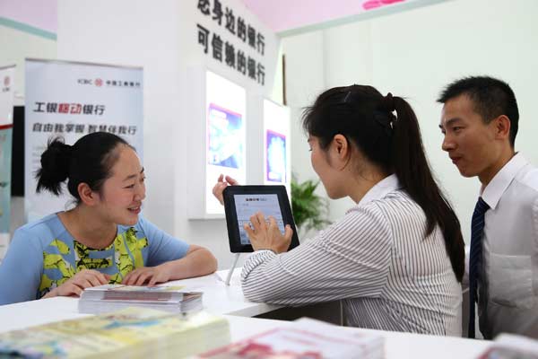 ICBC employees offer services to a customer at an ICBC branch in Haikou, Hainan province. (Photo by Zhang Mao/For China Daily)