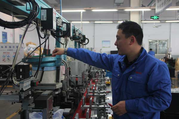 A worker operates the ballpoint pen production line of Beifa Group in Ningbo, Zhejiang province. (Photo provided to China Daily)