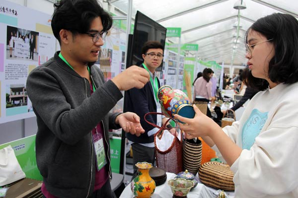 Two college students exchange ideas about new products at a fair to boost innovation and entrepreneurship in Shanghai. (Photo/Xinhua)