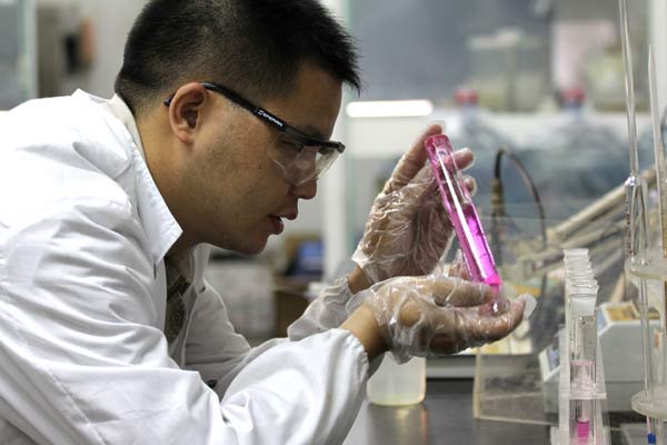 A technician from Dow Chemical Co checks sample of waste water in Nantong, Jiangsu province. (Photo/Xinhua)