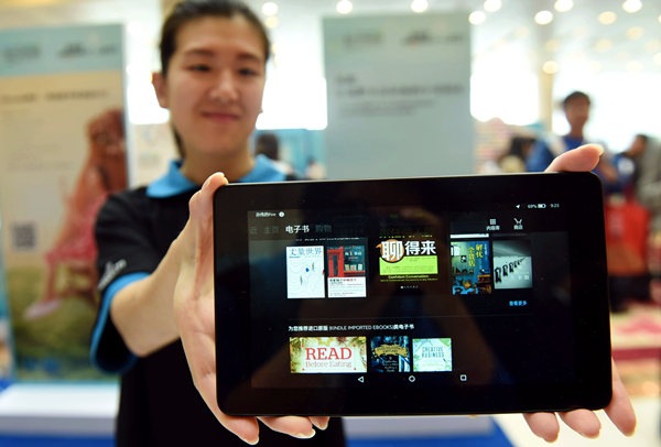 An Amazon worker displays a Kindle reader, in Hangzhou, Zhejiang province. LONG WEI / FOR CHINA DAILY