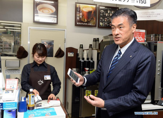 Genichi Tamatsuka (R), CEO of Lawson, experiences the Alipay at a Lawson convenience store in Tokyo, Japan, Jan. 23, 2017. (Xinhua/Ma Ping)