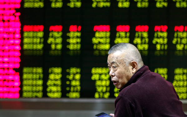 An investor checks out stock movements at a brokerage in Beijing on Friday, the first trading day of the Year of the Rooster. (Photo/China Daily)