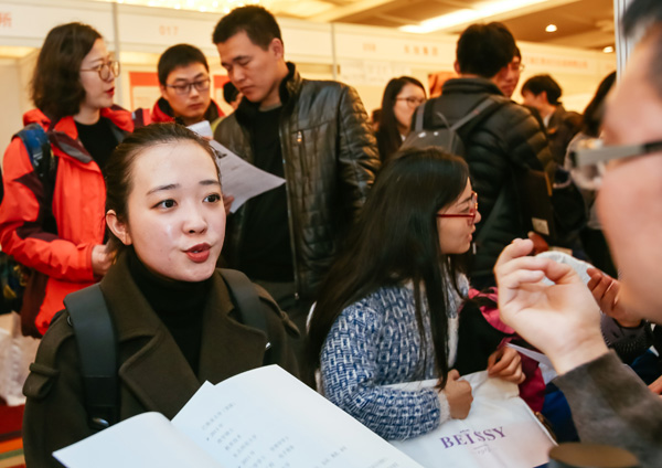 A job hunter talks with a company representative at a job fair in Beijing. (Photo/Xinhua)