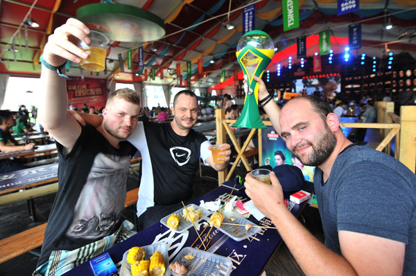 Foreign tourists down drinks during the Qingdao Beer Festival in Qingdao, Shandong province. (Photo/China Daily)
