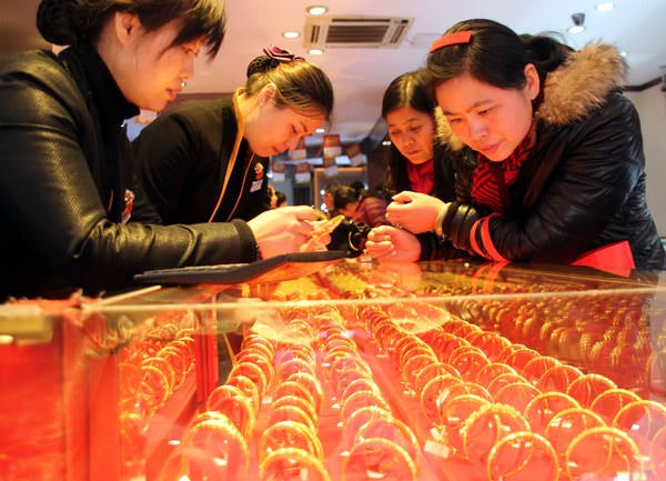 Customers select bracelets at a jewelry store in Suzhou, Jiangsu province, on Jan 31. WANG JIANKANG /FOR CHINA DAILY