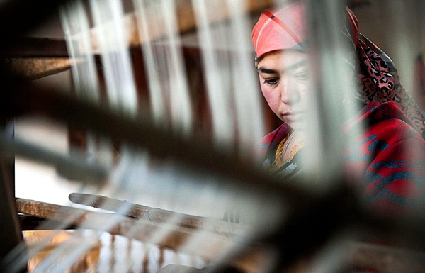 A worker uses a spinning wheel to produce silk in Hotan, Xinjiang Uygur autonomous region, in November. (Wei Hai/Xinhua)