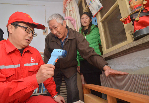 A worker of the geothermal arm of Sinopec Group checks the temperature of a room heated by geothermal power at a house in Zhengzhou, Henan province. TONG JIANG /FOR CHINA DAILY