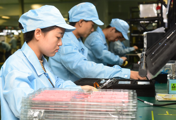 Workers assemble smartphones at a ZTE Corp plant in Xi'an, Shaanxi province. YUAN JINGZHI / FOR CHINA DAILY