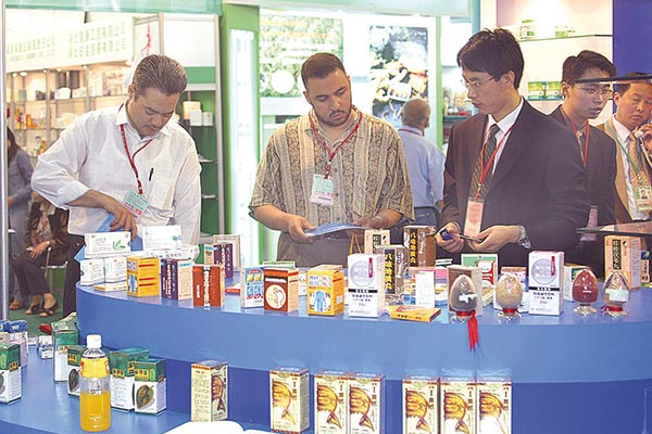 Some European businessmen inspect traditional Chinese medicine products of a drug store in Guangzhou. (Photo provided to China Daily)