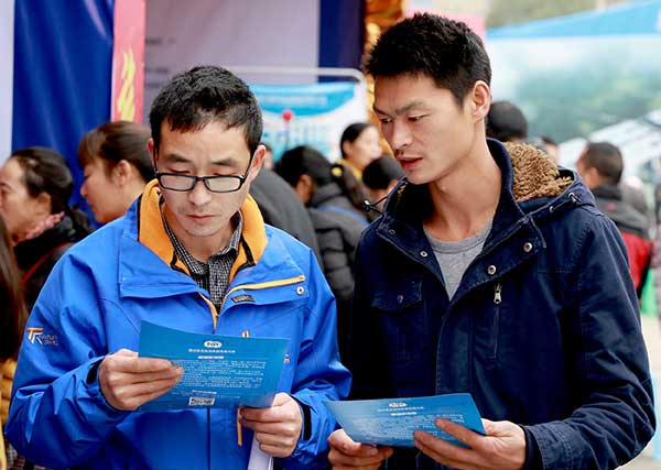 Job seekers read leaflets at a fair in Huaying, Sichuan province, earlier this month. Most attendees were seeking local work rather than migrating to bigger cities. (Zhou Songlin/For China Daily)