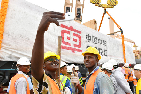 Workers take a selfie at a locomotive delivery ceremony in Mombasa, Kenya. The eight China-made locomotives will be used on the Mombasa-Nairobi railway. (Photo/Xinhua)