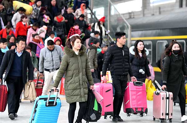 Passengers head to board trains at the Bozhou Railway Station in Anhui province on Tuesday, the last day of the Spring Festival travel rush.(Liu Qinli/For China Daily)