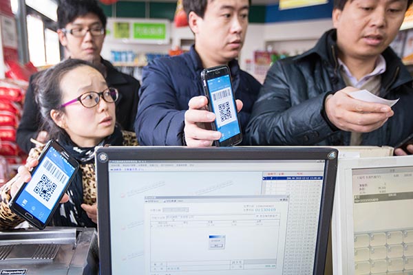 Bargain-hunters flash the Alipay Wallet QR codes on their smartphones at a Hangzhou supermarket checkout to claim a 10 percent discount on their shopping. (Photo provided to China Daily)