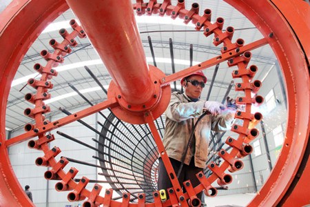 A worker prepares a steel frame for an expressway bridge in Youxian county in Hunan province. (Photo/China Daily))