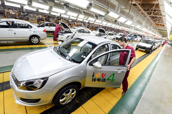 Technicians examine electric cars at a production line of JAC Motors. The automaker will start manufacturing cars for its partner NextEV later this year.  (Photo provided to CHINA DAILY)