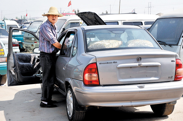 A dealer waits to sell a used car at a trade center in Zaozhuang, Shandong province. (Photo/CHINA DAILY)