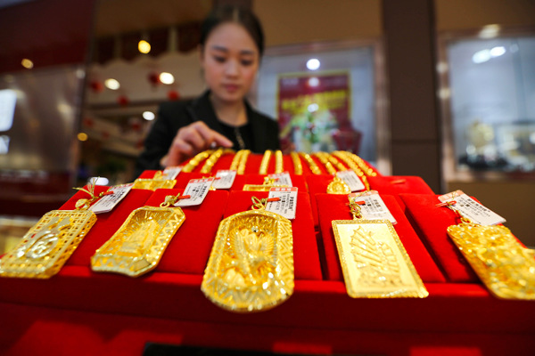 A staff member at a gold store arranges jewelry in Lianyungang, Jiangsu province, on Nov 6, 2016. SI WEI / FOR CHINA DAILY