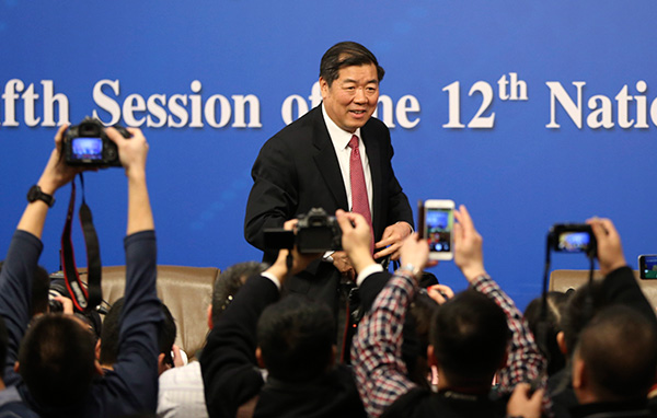 He Lifeng, minister of the National Development and Reform Commission, talks with reporters on the sidelines of the NPC session in Beijing on Monday.(Photo by Feng Yongbin/China Daily)