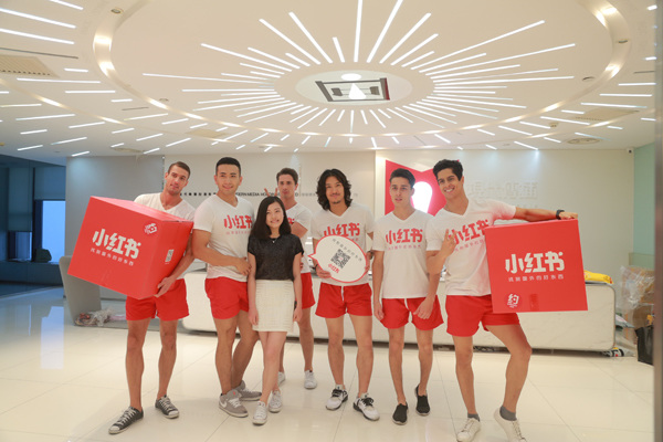 A female user of Red (Xiao Hongshu) poses with the company's staff at its anniversary celebration in Shanghai. (Photo provided to China Daily)