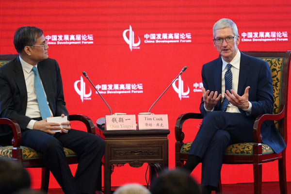 Apple CEO Tim Cook (right) talks to Professor Qian Yingyi, dean of School of Economics and Management, Tsinghua University at the 18th China Development Forum (CDF) in Beijing on March 18, 2017. (Photo:chinadaily.com.cn/Feng Yongbin)