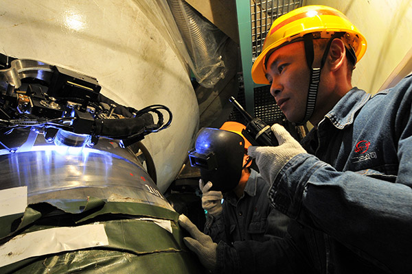 Technicians control an automatic welding operation of a nuclear reactor at the Ningde nuclear power plant in Fujian province. (Photo/Xinhua)