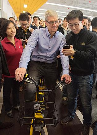 Tim Cook, CEO of Apple Inc, tries a bike at the headquarters of bike-sharing startup ofo Inc in Beijing on Tuesday. (Photo/Tim Cook's sina weibo)