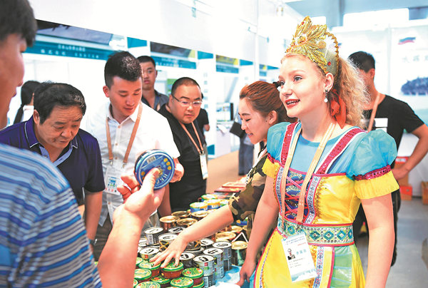 Visitors to the ChinaRussia Expo in Harbin, capital of Heilongjiang province, check goods from Russia in June last year. The province has close trade ties with Russia, which it borders on. WANG JIANWEI / XINHUA