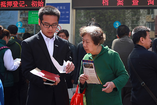 A housing agent helps a client complete property transactions in Beijing. (Photo/China Daily)